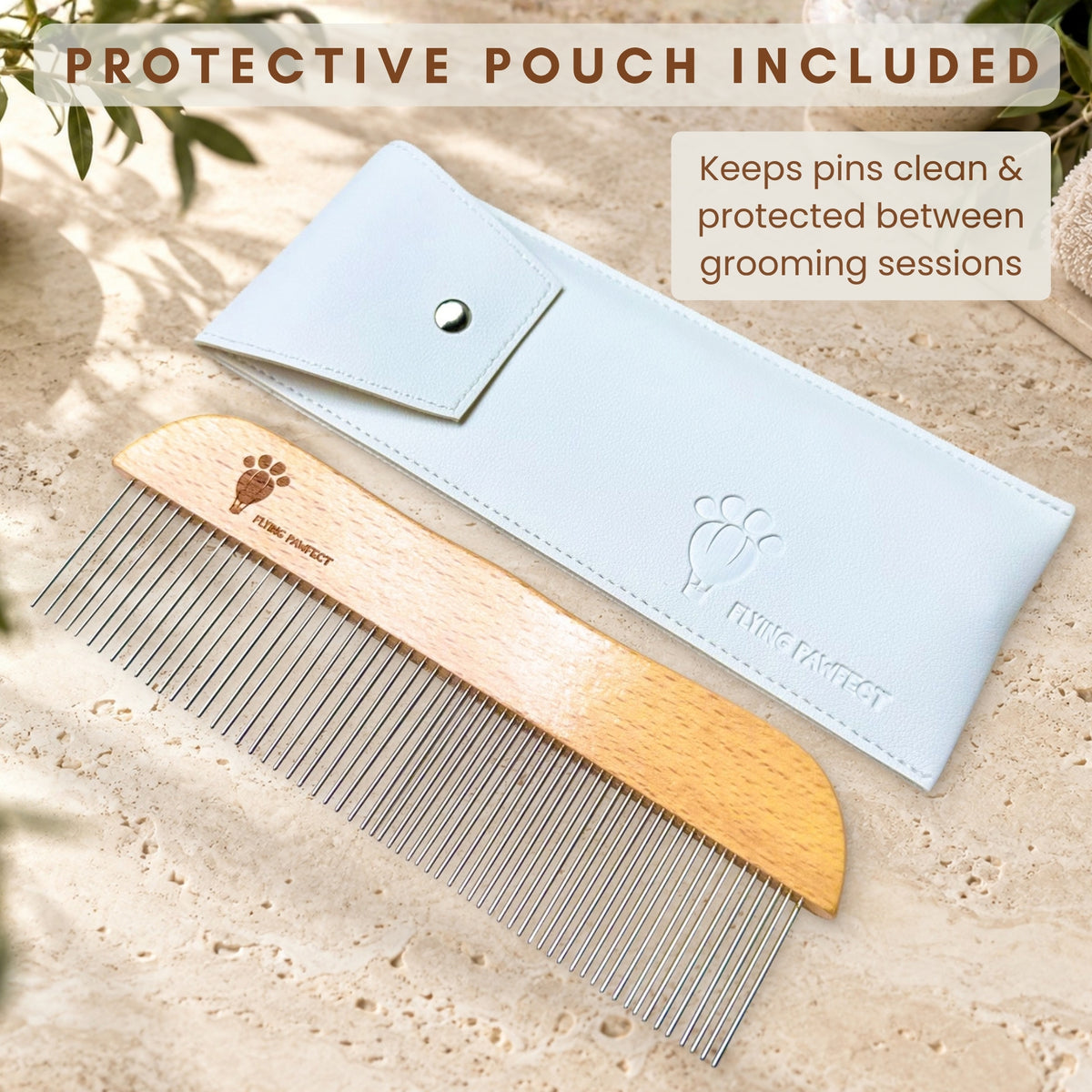The Flying Pawfect Long Tooth Comb lying beside its white protective pouch on sand